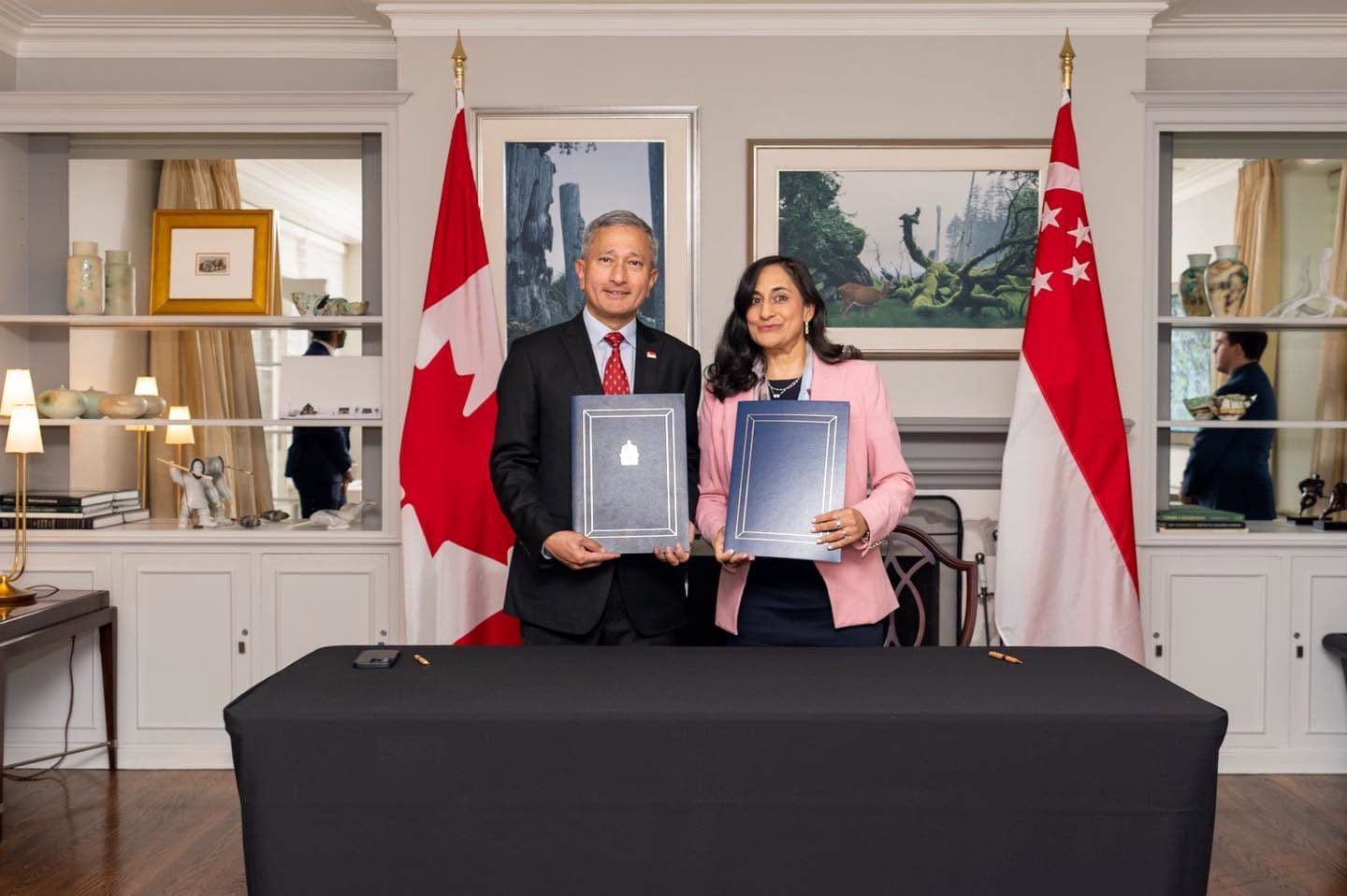 Vivian Balakrishnan and Anita Anand hold signed copies of a Singapore-Canada joint statement in Ottawa