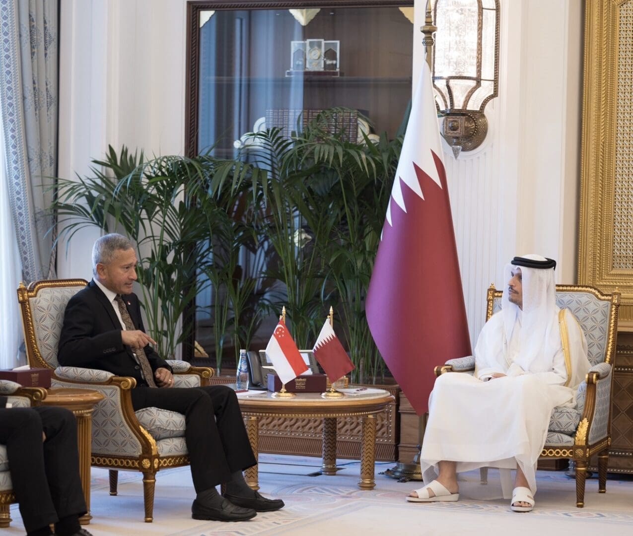 Current image: Singapore and Qatar officials meeting in Doha with Singapore and Qatar flags displayed.