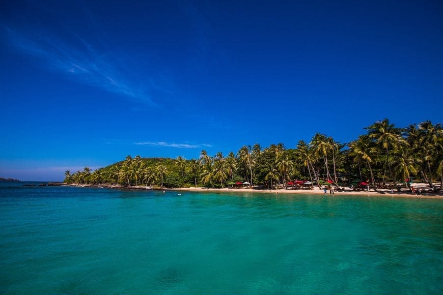 Clear turquoise waters and a palm-fringed beach along the coast of Phu Quoc